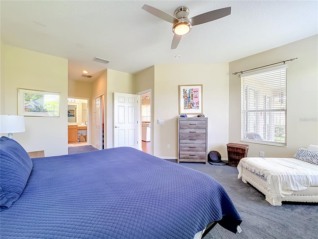 A bedroom features a blue bed, a ceiling fan, a dresser, and a daybed — 4346 KARIBA LAKE TERRACE, SARASOTA, FL