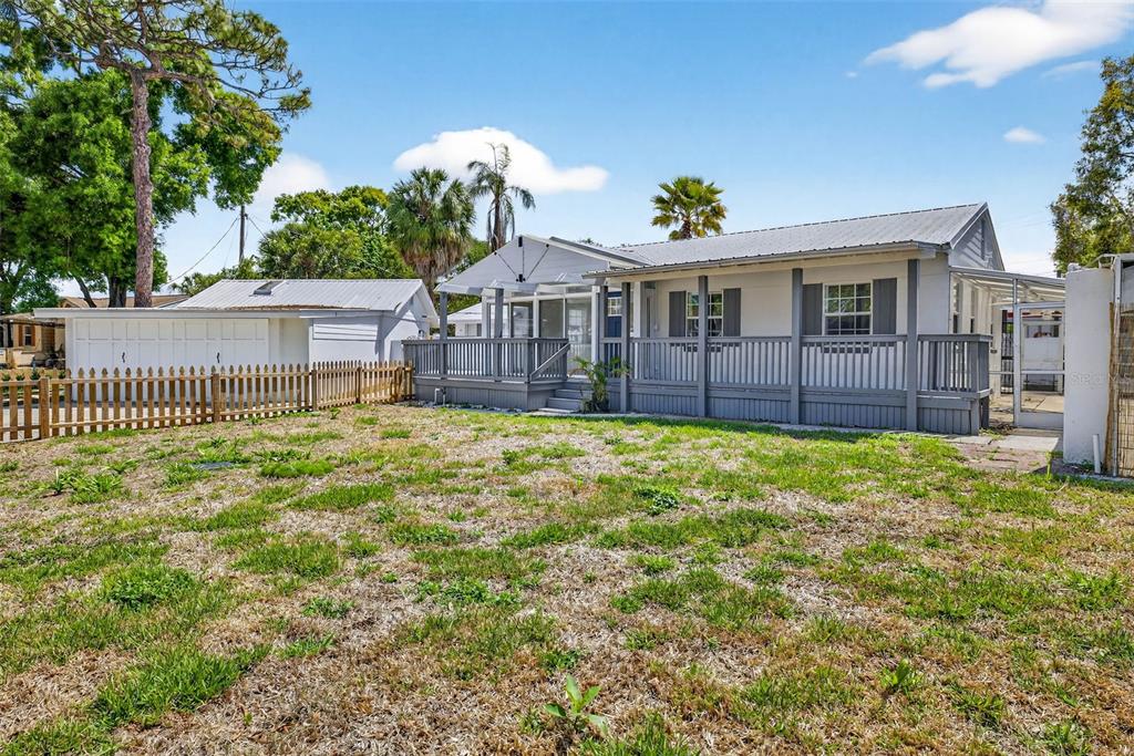 A single-story house with a large wooden deck and a detached garage in the yard — 3620 E TAMPA CIRCLE, TAMPA, FL