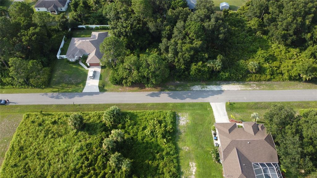 An aerial view shows two houses separated by a road and surrounding wooded lots — LOT 12 ATTALLA AVENUE, NORTH PORT, FL