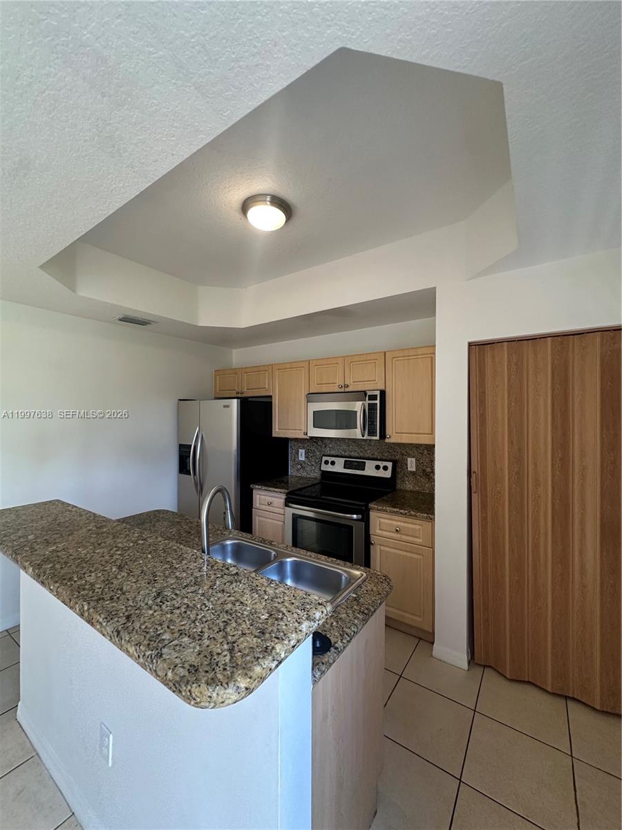 A kitchen features light wood cabinets, granite countertops, stainless steel appliances, and a breakfast bar — 2191 Anchor Ct # 1902, Dania Beach FL 33312, DANIA BEACH, FL