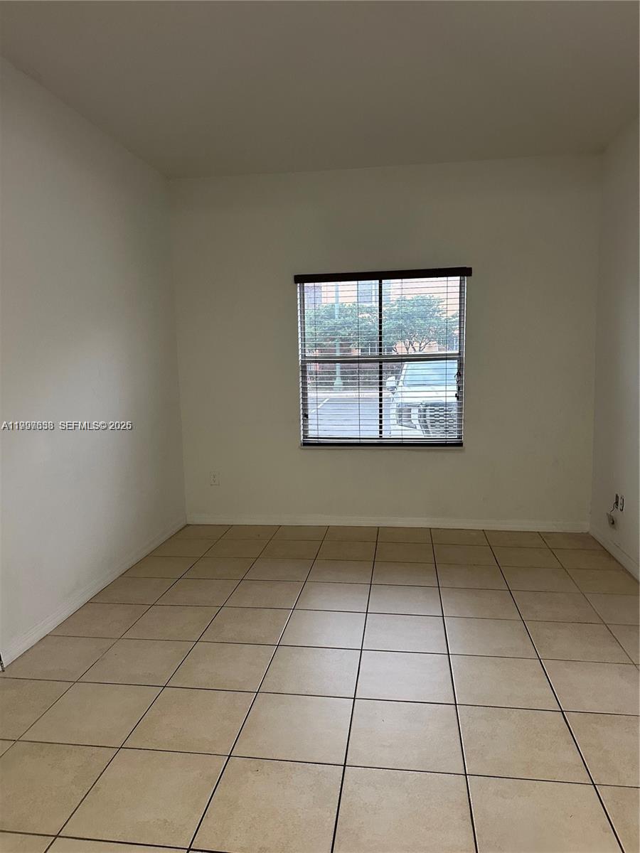 An empty room features light-colored tile flooring, white walls, and a single window with blinds — 2191 Anchor Ct # 1902, Dania Beach FL 33312, DANIA BEACH, FL