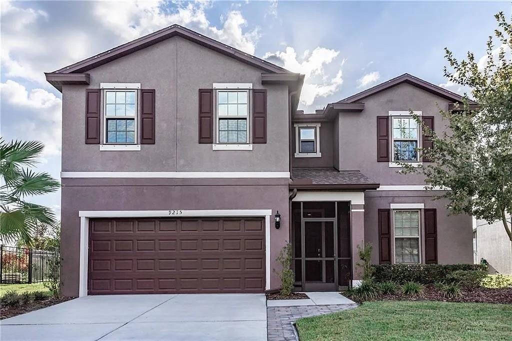 A two-story house with a gray stucco exterior, brown shutters, and a two-car garage — 9215 MOUNTAIN MAGNOLIA DRIVE, RIVERVIEW, FL