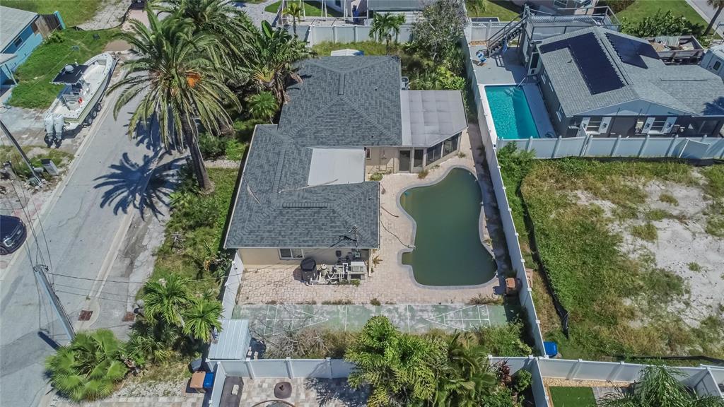 An aerial view of a house with a green swimming pool and a shuffleboard court — 363 145TH AVENUE E, MADEIRA BEACH, FL