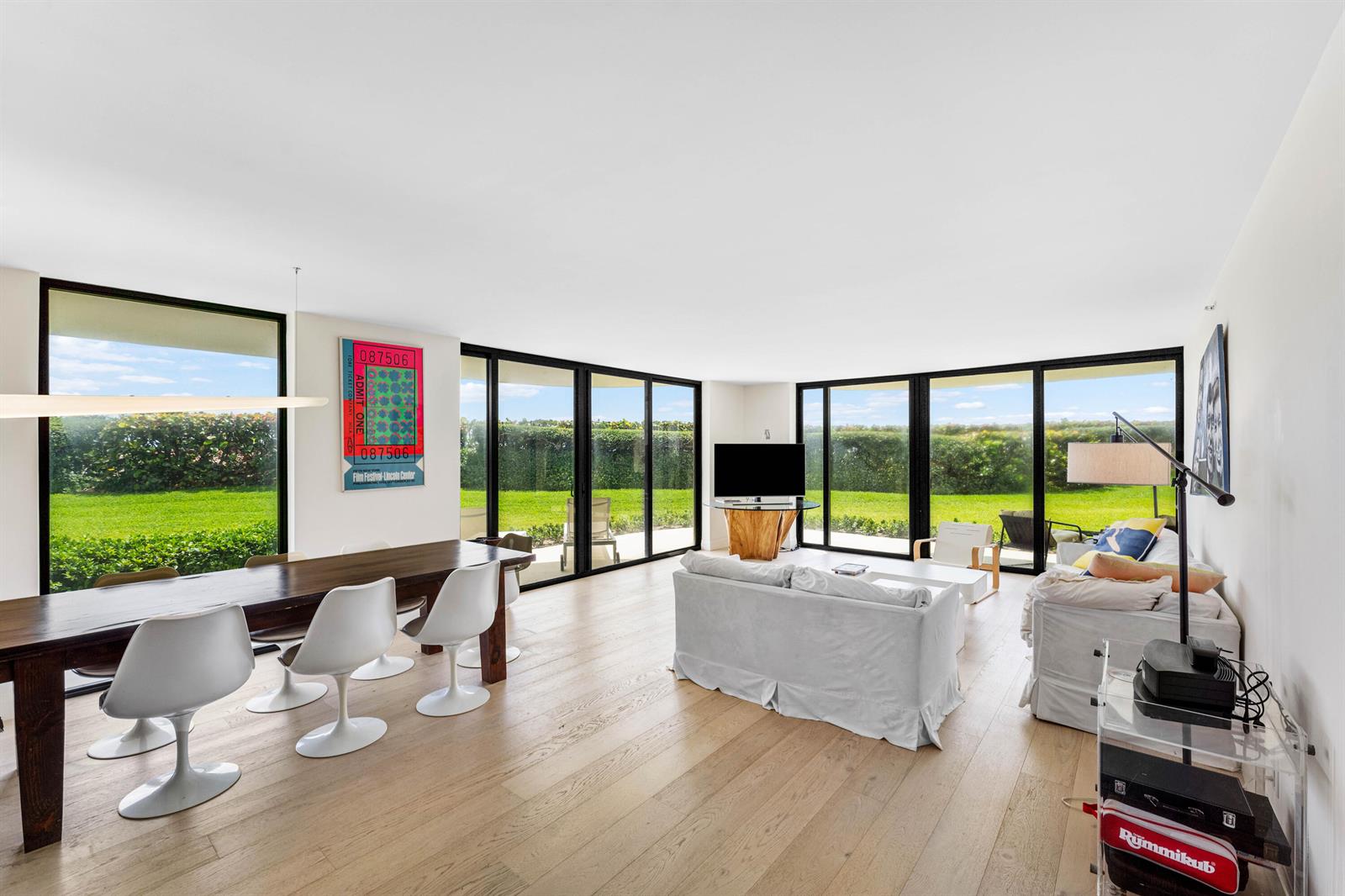 A bright living and dining area features floor-to-ceiling windows, light wood floors, and modern furniture — 3360 S Ocean Boulevard # I, Palm Beach FL 33480, PALM BEACH, FL