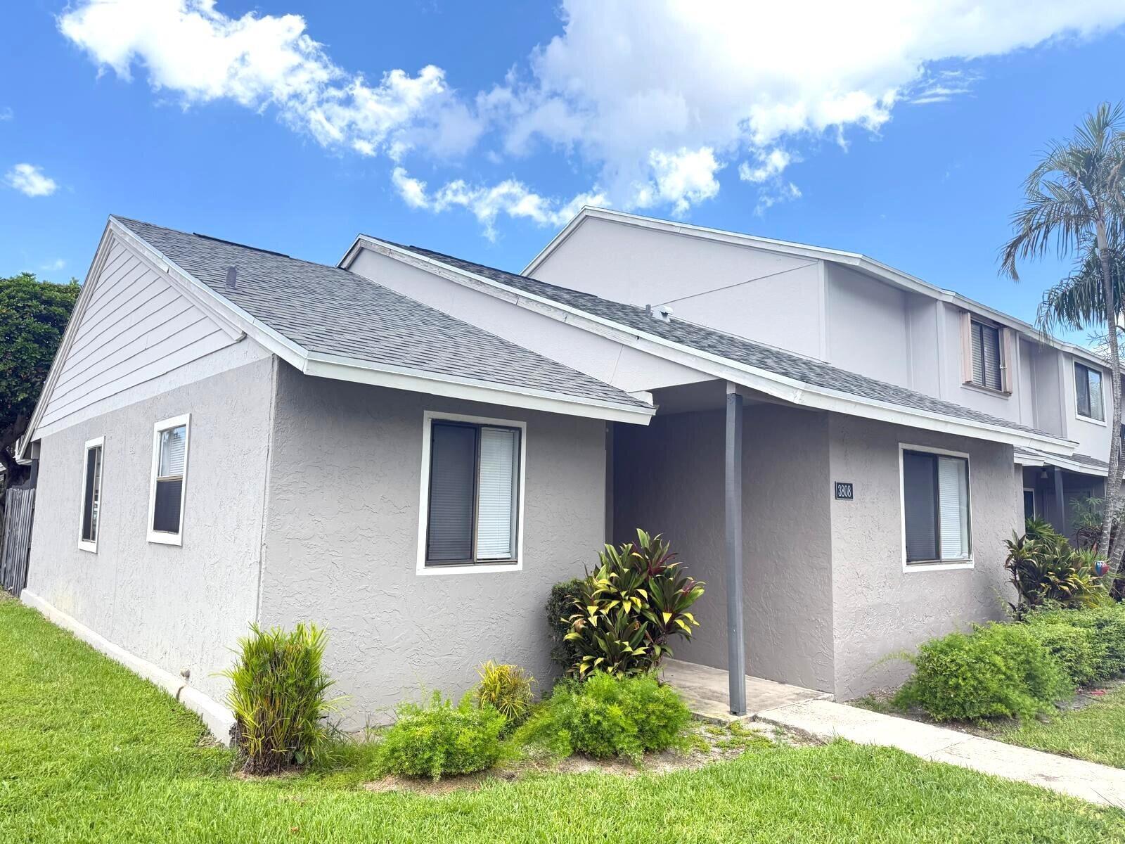 A gray, single-story residential building with a shingled roof and a small front porch — 3808 Inlet Circle # 3808, FL 33463, FL
