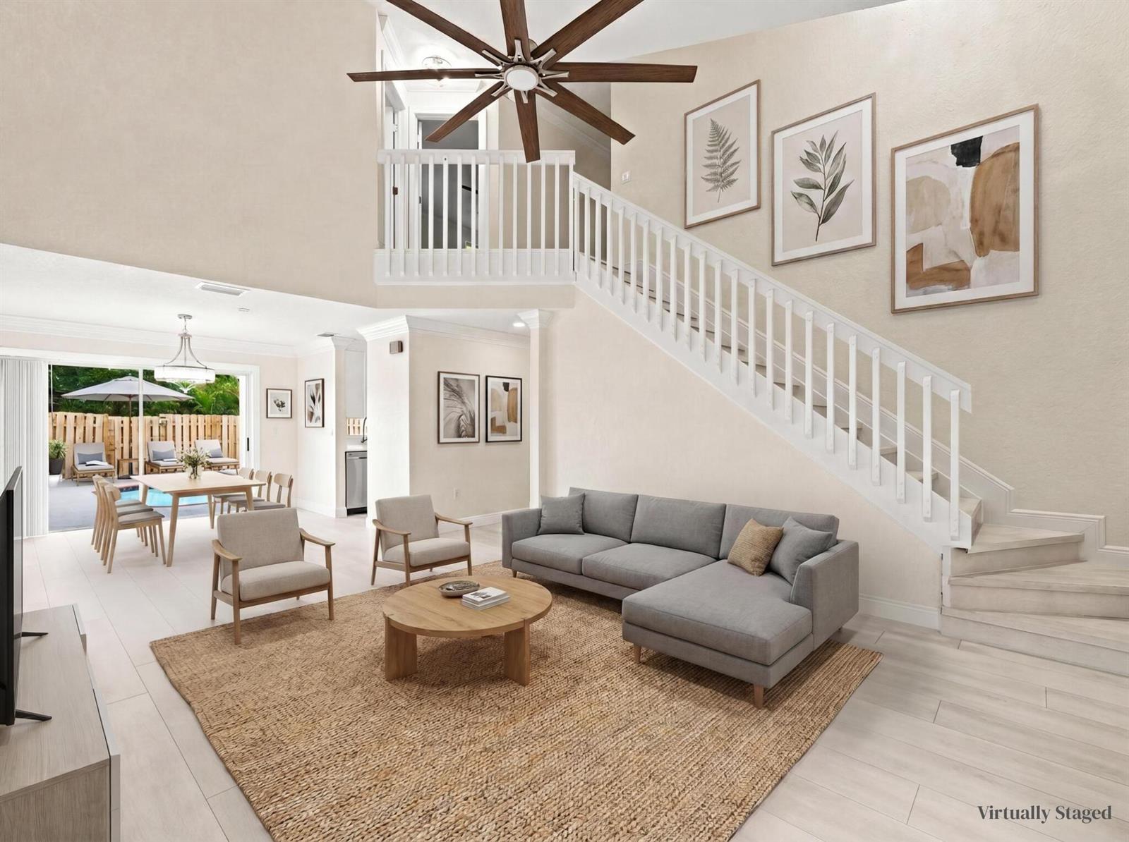 A living room with a staircase, gray sectional sofa, and a view of a patio — 3157 NW 120th Way, Sunrise FL 33323, SUNRISE, FL