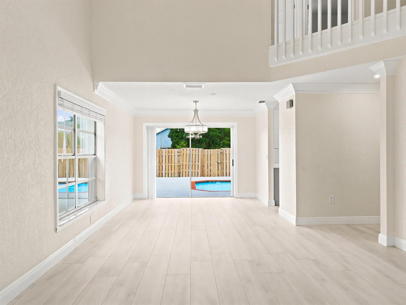 An empty dining room with light wood floors, a chandelier, and sliding doors to a pool — 3157 NW 120th Way, Sunrise FL 33323, SUNRISE, FL