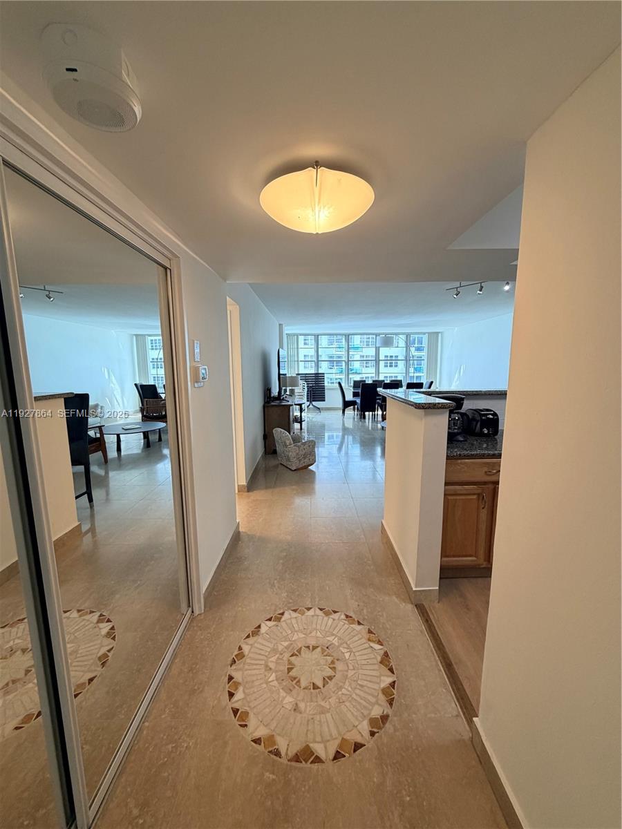 A tiled entryway with a circular mosaic inlay leads into an open-concept living and dining area — 5151 Collins Ave, Miami Beach FL 33140, MIAMI BEACH, FL