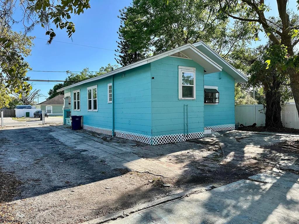 A side view of a turquoise house with a concrete driveway and lattice skirting — 1504 E 33RD AVENUE, TAMPA, FL