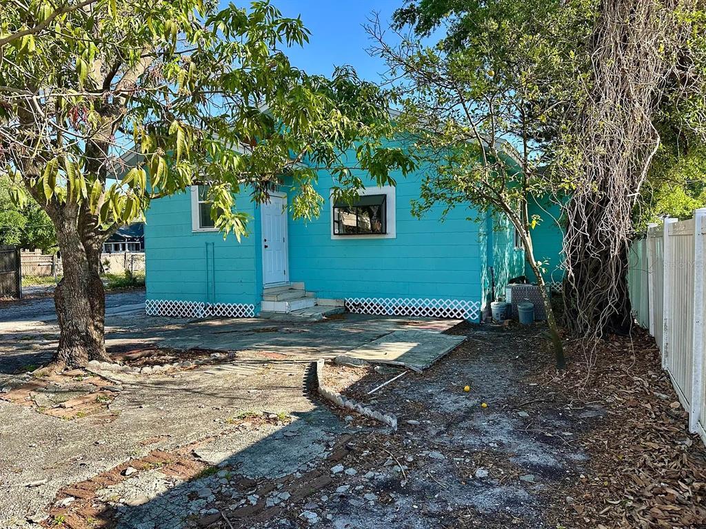 A bright turquoise house with a white door and lattice skirting sits on a concrete lot — 1504 E 33RD AVENUE, TAMPA, FL