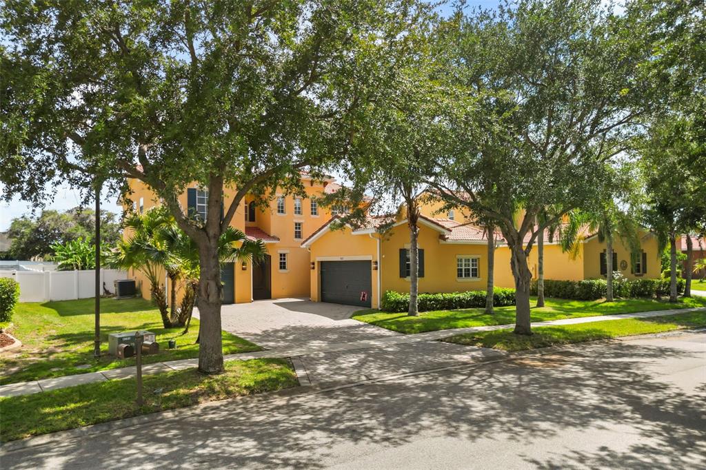 A two-story yellow stucco house with a tile roof and a paved driveway — 3827 GOLDEN KNOT DRIVE, KISSIMMEE, FL