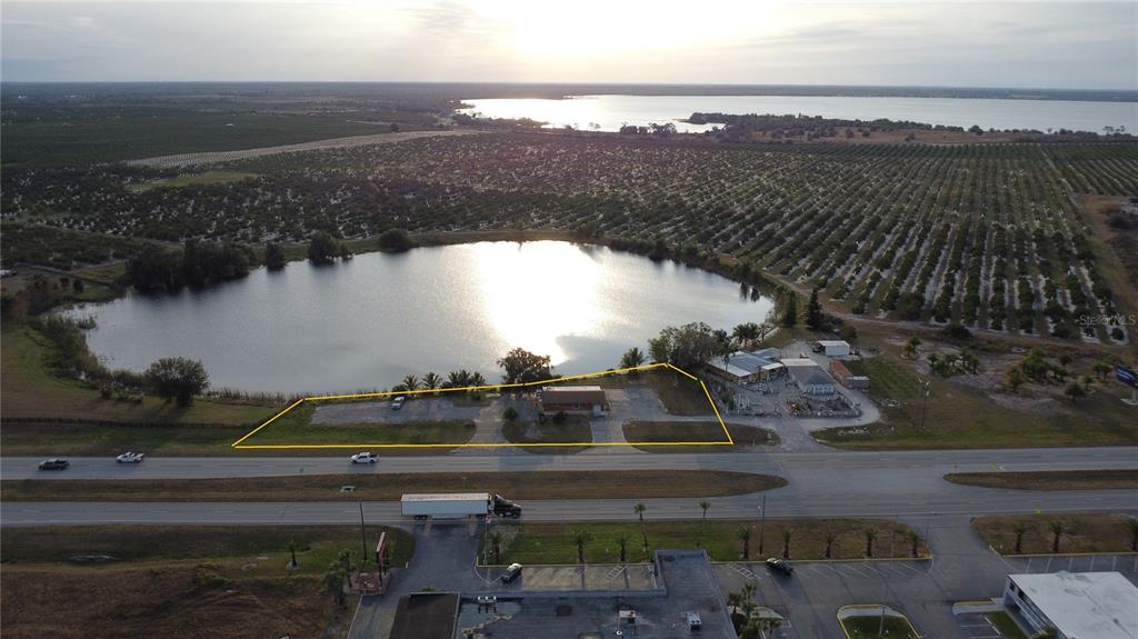 An aerial view shows a small building on a lot bordering a lake and highway — 2200 - 2204 US 27 HIGHWAY S, LAKE PLACID, FL