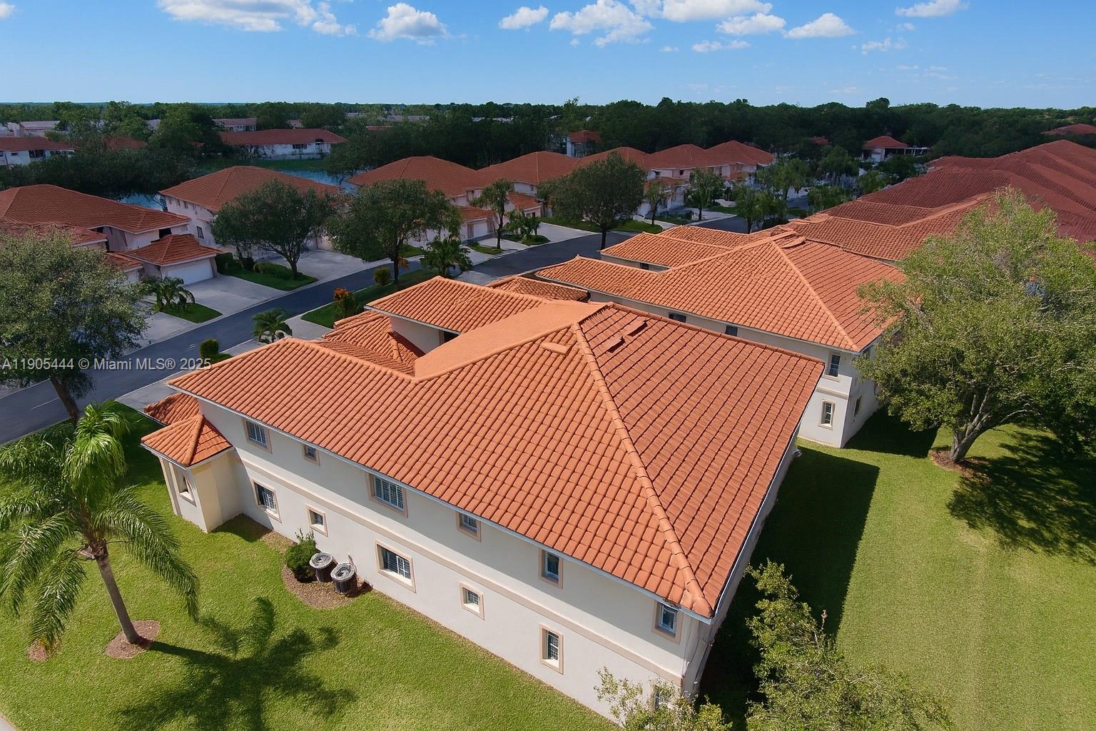 An aerial view shows a multi-story residential building with a red tile roof — OTHER CITY - IN THE STATE OF FLORIDA, FL
