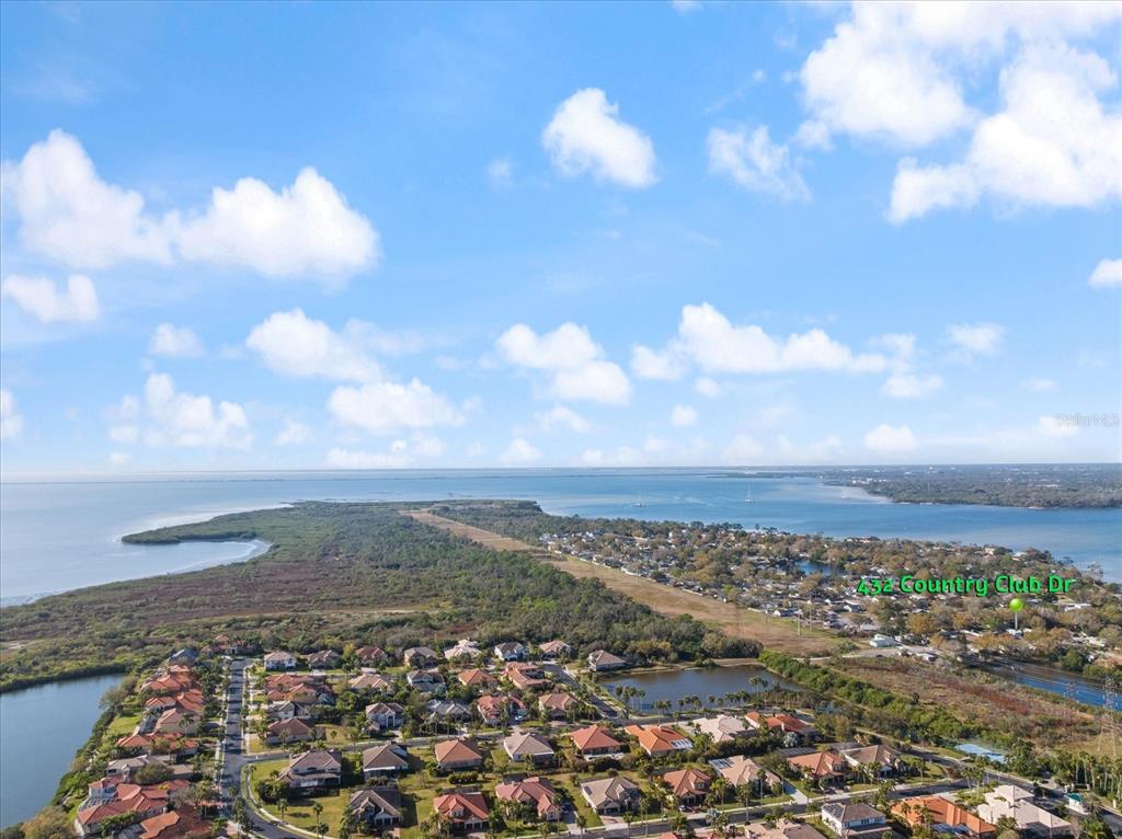 An aerial view shows a residential neighborhood situated along a coastal inlet and forest — 432 COUNTRY CLUB DRIVE, OLDSMAR, FL