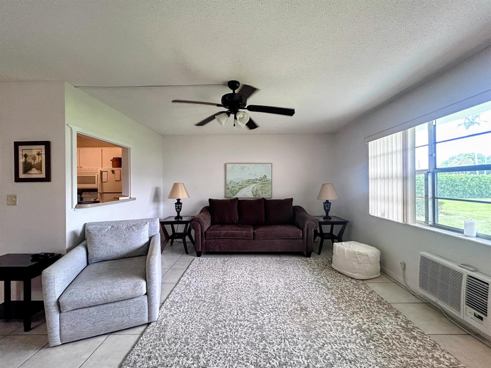 A living room features a brown sofa, a gray armchair, and a ceiling fan — 680 W Horizons W # 103, Boynton Beach FL 33435, BOYNTON BEACH, FL
