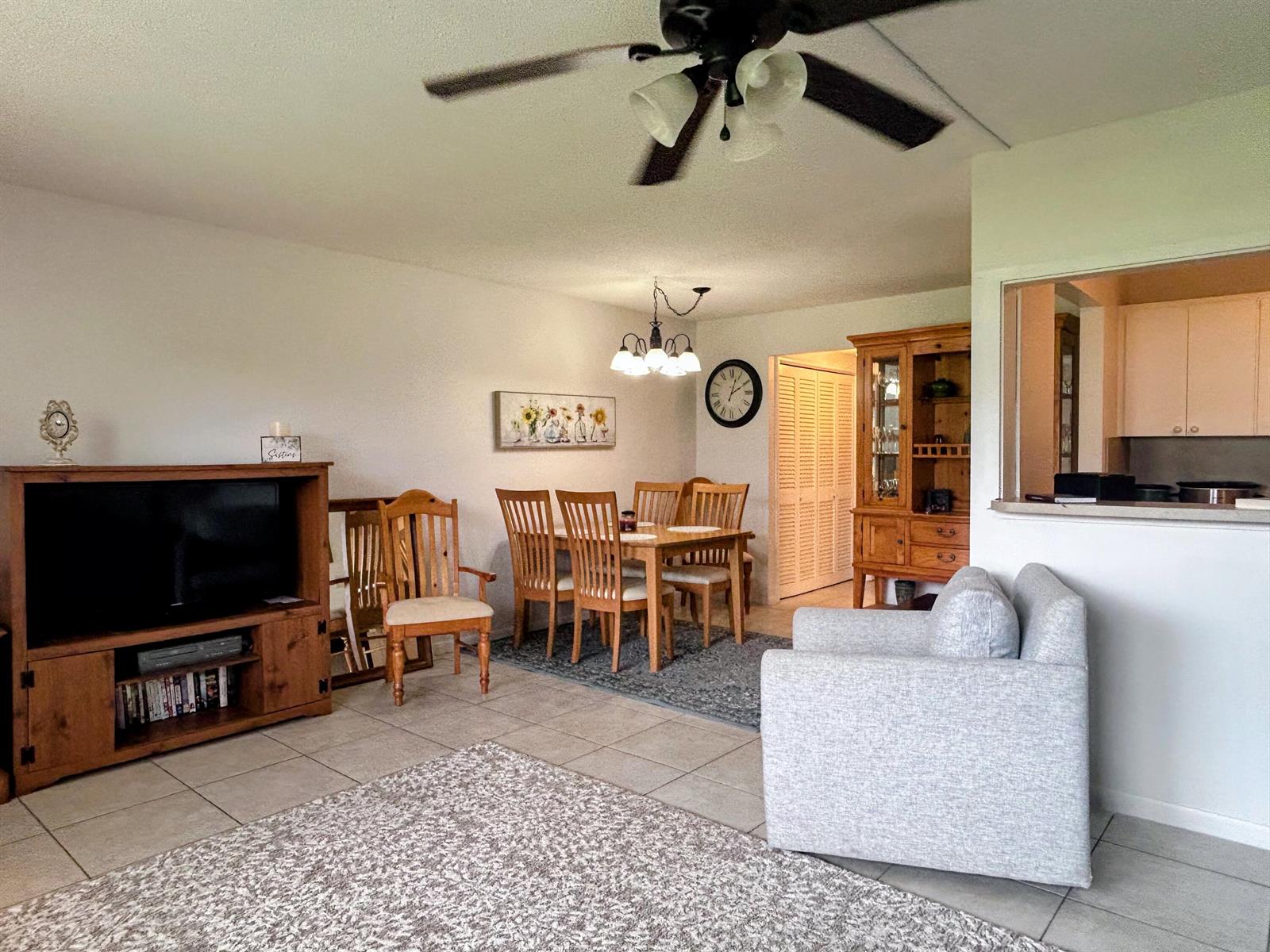A living and dining room area features tile flooring, a ceiling fan, and wooden furniture — 680 W Horizons W # 103, Boynton Beach FL 33435, BOYNTON BEACH, FL