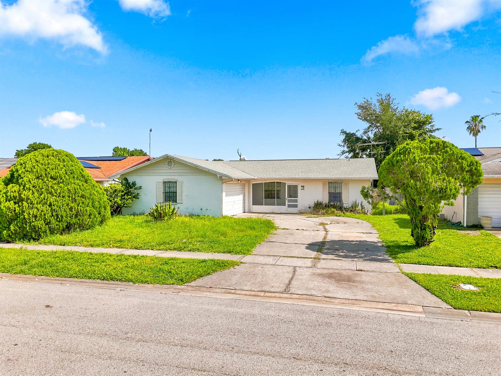 A single-story house with a concrete driveway, a front lawn, and two large green bushes — 2737 Myakka Drive, Orlando FL 32839, ORLANDO, FL