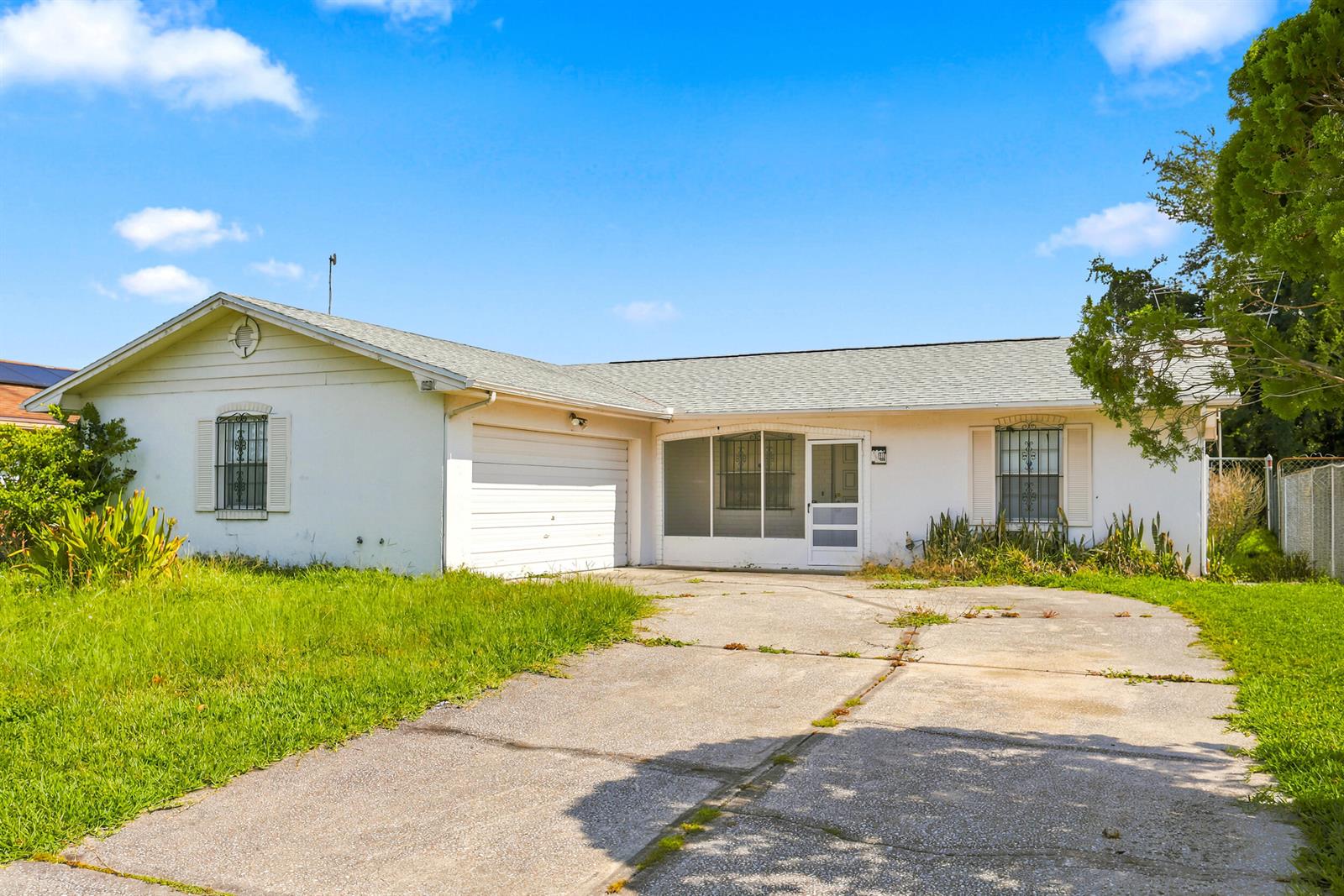A single-story white house with a garage, a screened entryway, and a concrete driveway — 2737 Myakka Drive, Orlando FL 32839, ORLANDO, FL