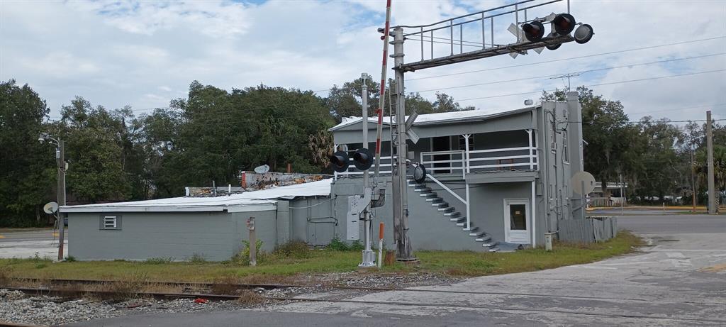 A two-story gray building stands next to a railroad crossing with a signal arm — 1700 US HIGHWAY 17 N, SEVILLE, FL