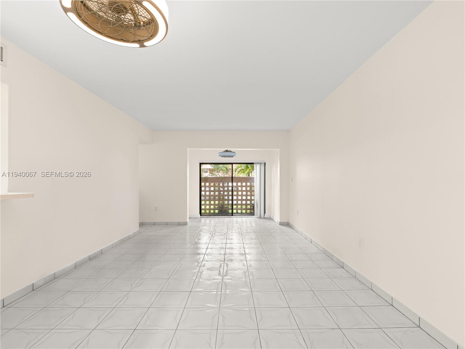 An empty room with white walls, light-colored tile flooring, and a sliding glass door — 10249 NW 9th St Cir # 8, Miami FL 33172, MIAMI, FL