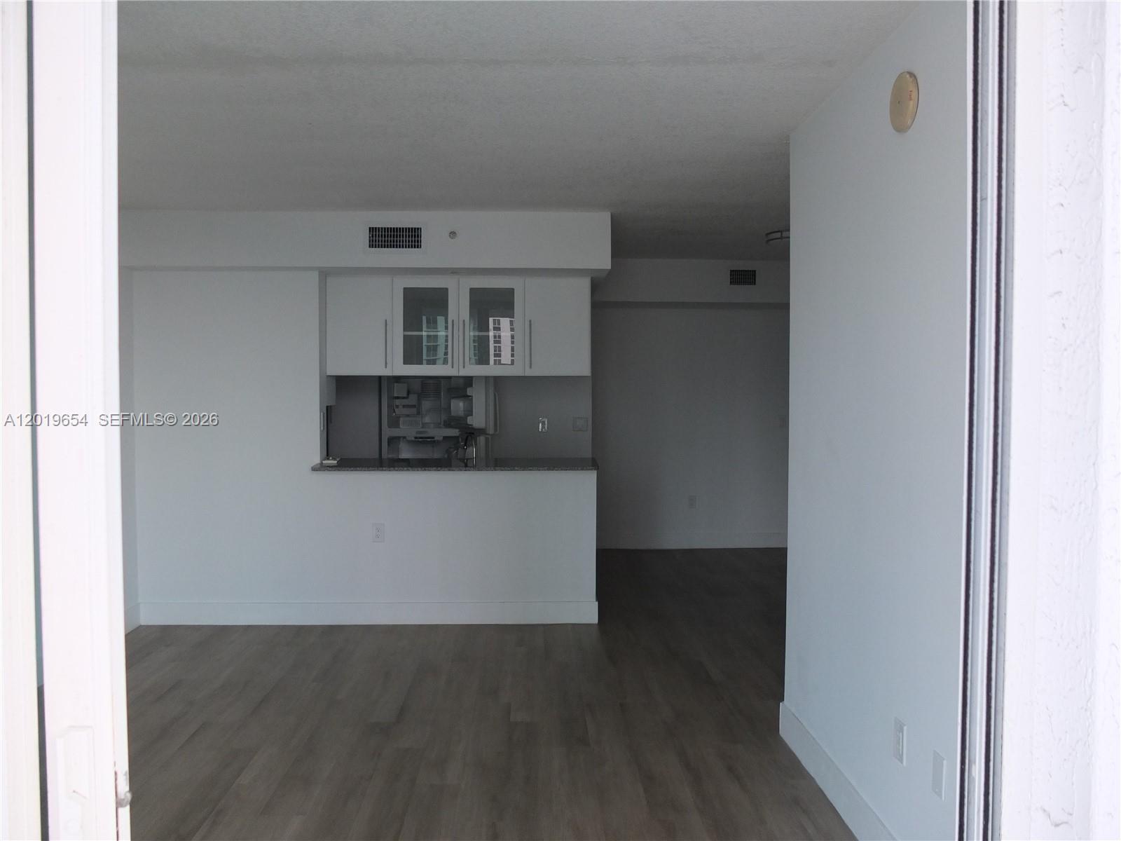 This interior view shows a kitchen with white cabinets and a pass-through counter — 275 NE 18th St # 1101, Miami FL 33132, MIAMI, FL