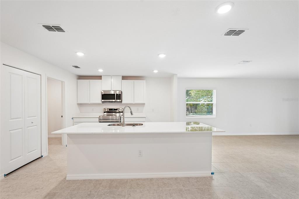 A kitchen with white cabinets, a central island, and light-colored tile flooring — 20247 ANDOVER AVENUE, PORT CHARLOTTE, FL