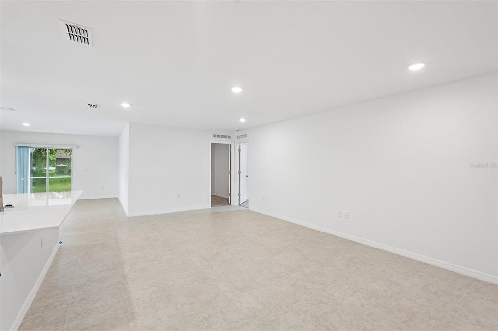 A bright, open-concept room features white walls, recessed lighting, and light-colored tile flooring — 20247 ANDOVER AVENUE, PORT CHARLOTTE, FL