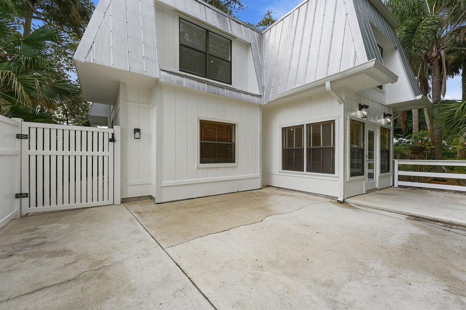 A white house with a metal roof and a concrete patio area — 576 SW Rustic Circle, Stuart FL 34997, STUART, FL