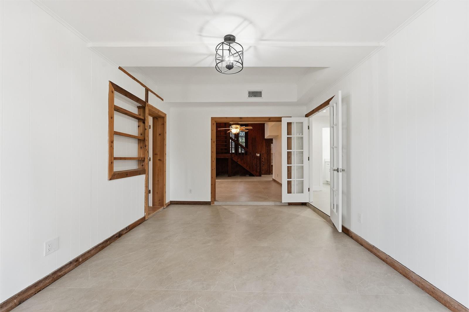 A bright room with white paneled walls, tile flooring, and a central industrial-style light fixture — 576 SW Rustic Circle, Stuart FL 34997, STUART, FL