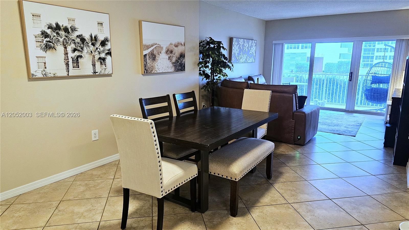 A dining area with a dark wood table, upholstered chairs, and a bench on tile — 1980 S Ocean Dr # 4L, Hallandale Beach FL 33009, HALLANDALE BEACH, FL