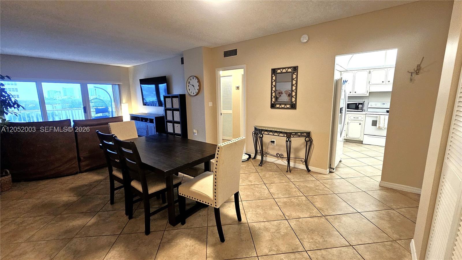 A dining area with a dark table and chairs sits adjacent to a tiled kitchen — 1980 S Ocean Dr # 4L, Hallandale Beach FL 33009, HALLANDALE BEACH, FL