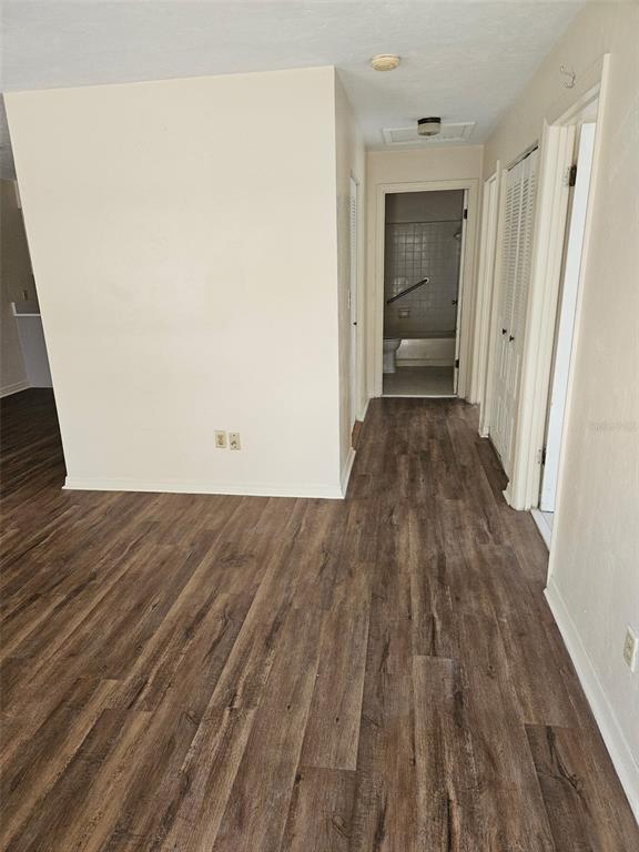 A hallway with wood-look flooring leads to a bathroom with a tub and shower — 5813 NW 23RD TERRACE UNIT ABCD, GAINESVILLE, FL