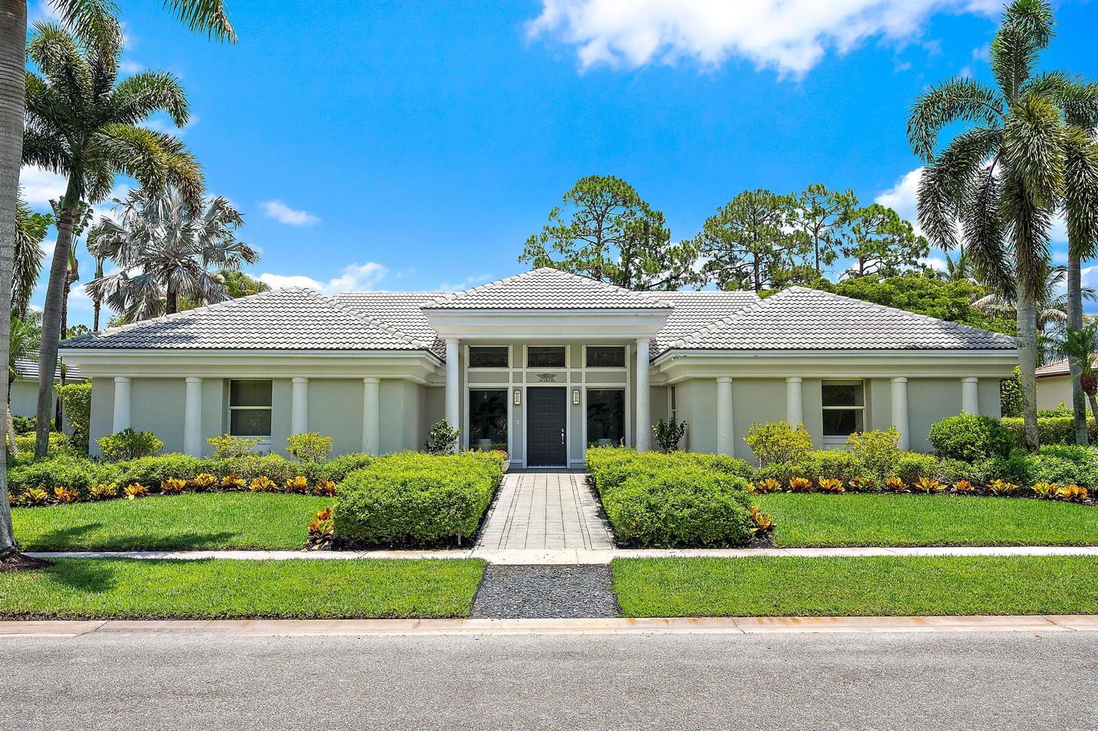 A single-story house with a tiled roof, columns, and a paved walkway through the lawn — 6070 Wildcat Run, West Palm Beach FL 33412, WEST PALM BEACH, FL
