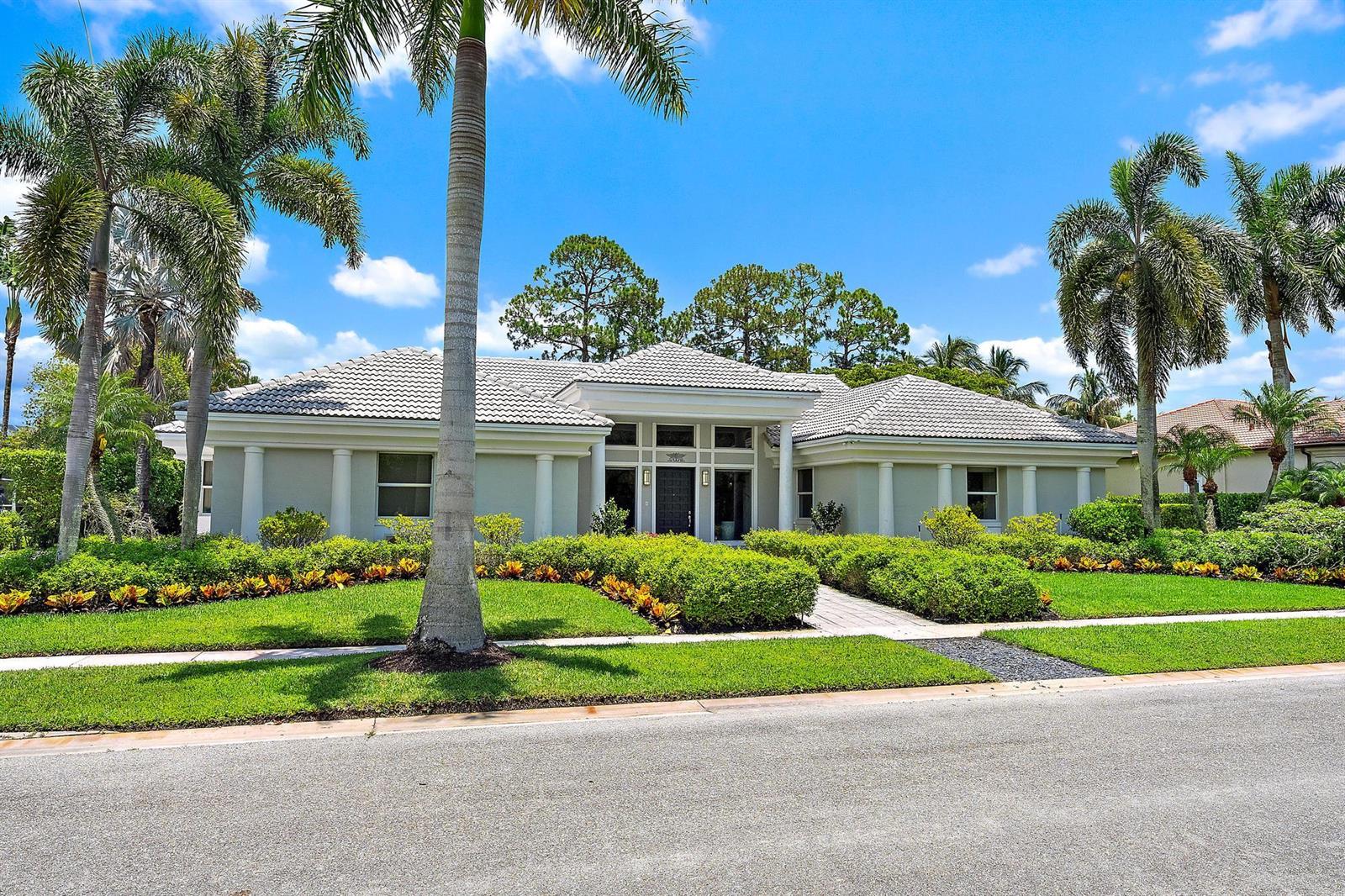 A single-story house with a tiled roof, white columns, and palm trees in the front yard — 6070 Wildcat Run, West Palm Beach FL 33412, WEST PALM BEACH, FL