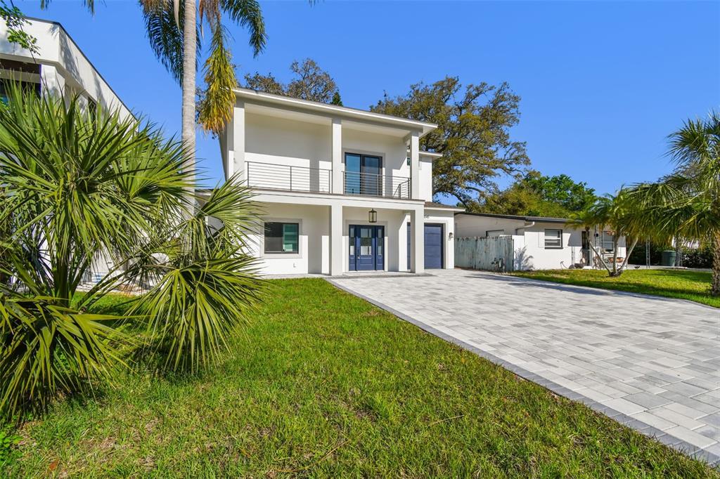 A two-story modern house with a paved driveway, white exterior, and a second-floor balcony — 1045 JESSE AVENUE, SAFETY HARBOR, FL