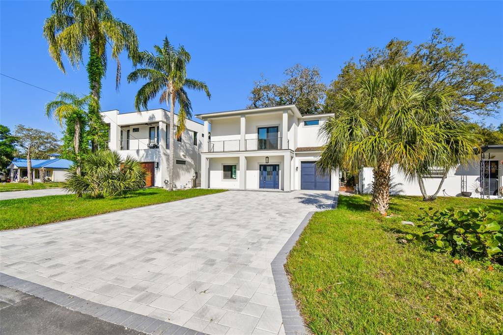 A two-story modern house with a paved driveway, a balcony, and palm trees — 1045 JESSE AVENUE, SAFETY HARBOR, FL