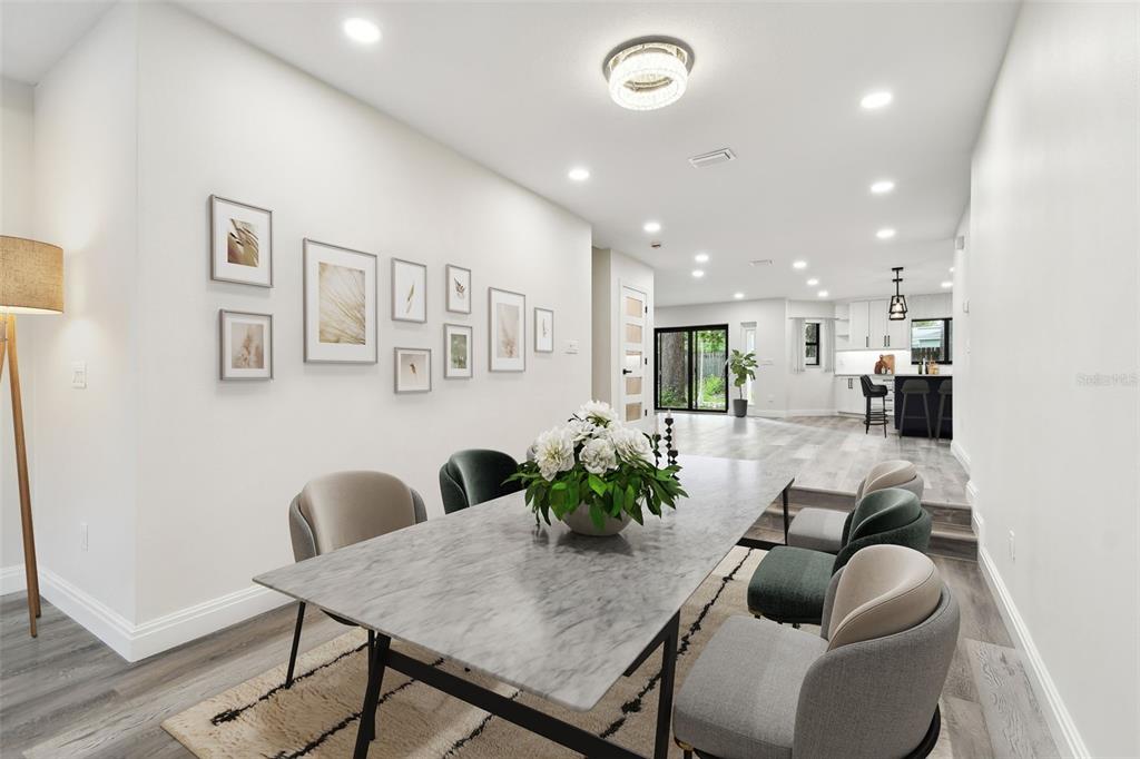 A dining area features a marble-topped table, upholstered chairs, and a gallery wall of framed art — 1045 JESSE AVENUE, SAFETY HARBOR, FL
