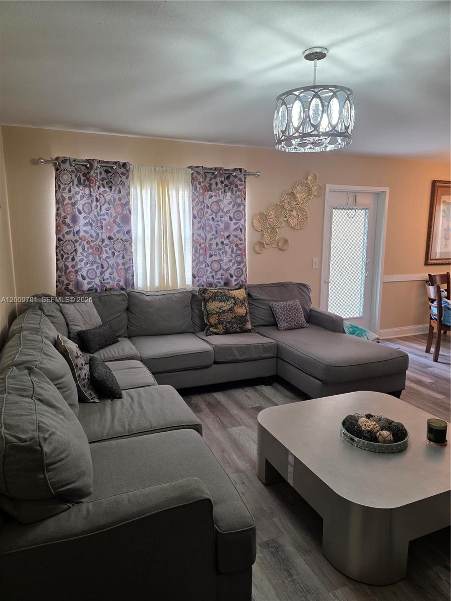 A living room features a large gray sectional sofa, a coffee table, and patterned curtains — 232 E Saxony E # 232, Delray Beach FL 33446, DELRAY BEACH, FL