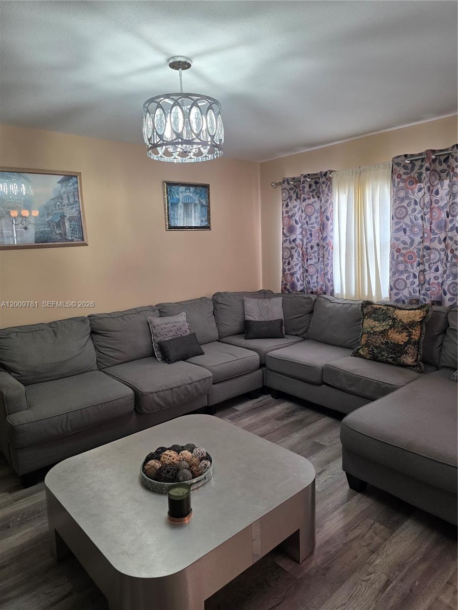 A living room features a large gray sectional sofa, a square coffee table, and patterned curtains — 232 E Saxony E # 232, Delray Beach FL 33446, DELRAY BEACH, FL