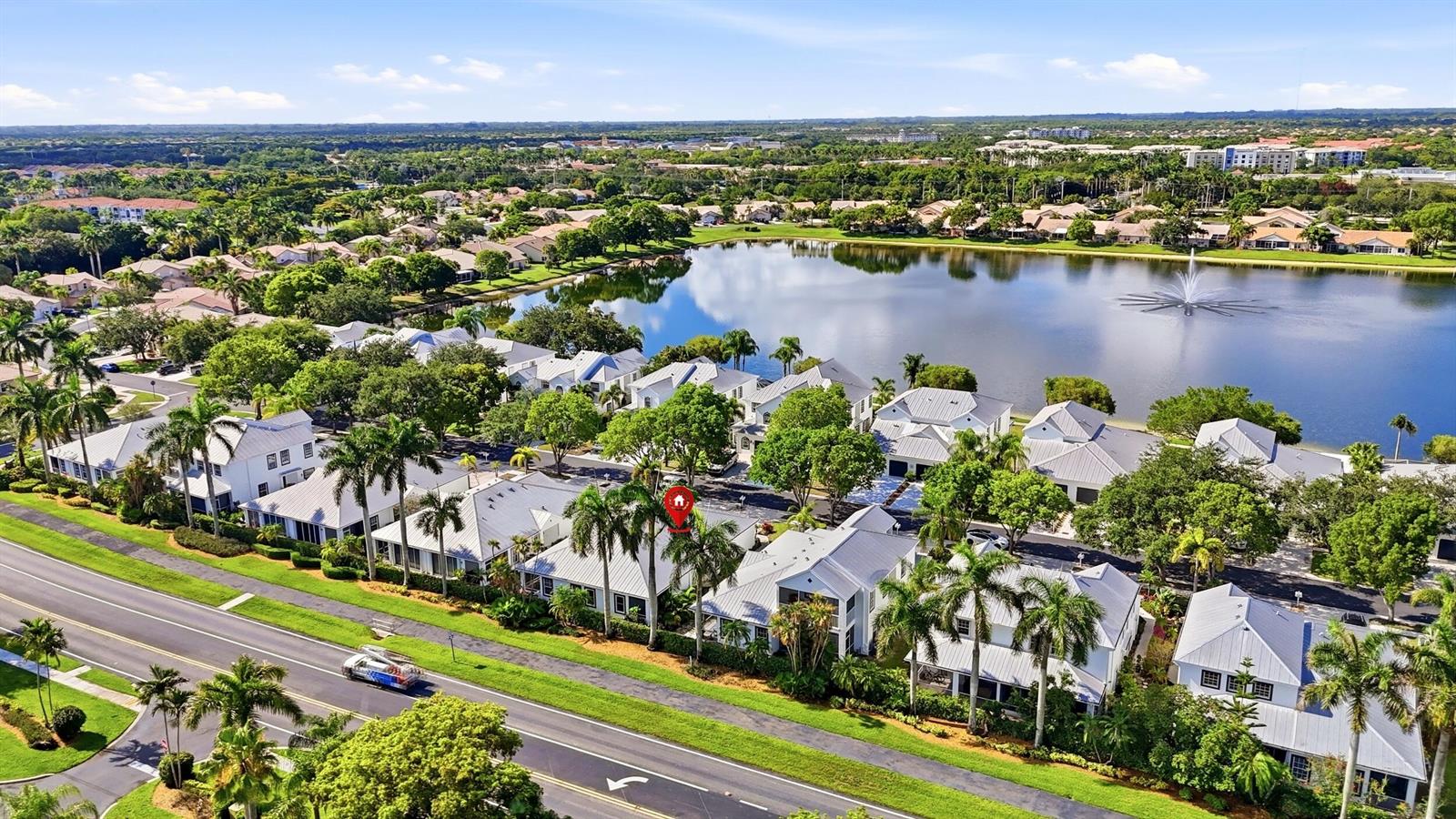 An aerial view shows a residential neighborhood with white houses, palm trees, and a lake — 10725 Pelican Drive, Wellington FL 33414, WELLINGTON, FL