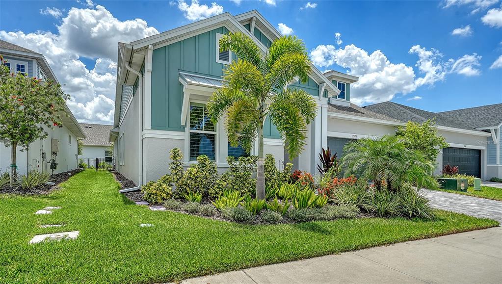 A teal and white house with a palm tree in the front yard — 1578 RUNNING TIDE PLACE, SARASOTA, FL