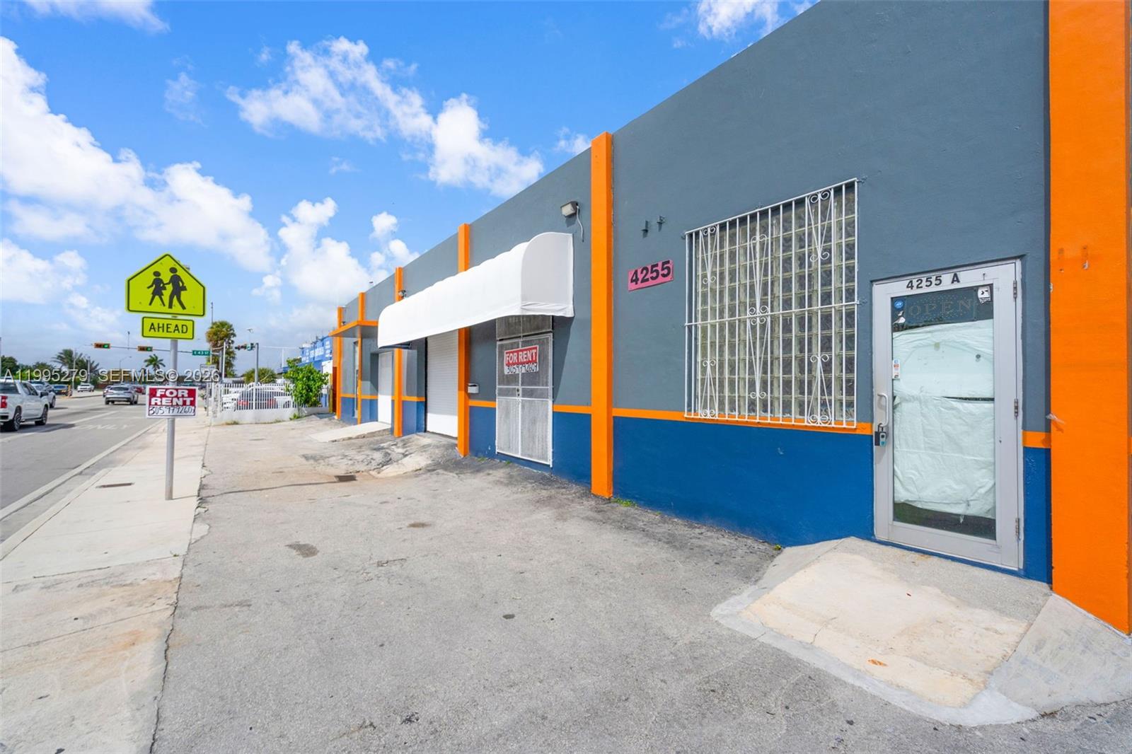 The exterior of a commercial building features gray and blue walls with orange vertical accents — 4255 E 8th Ave # 3, Hialeah FL 33013, HIALEAH, FL
