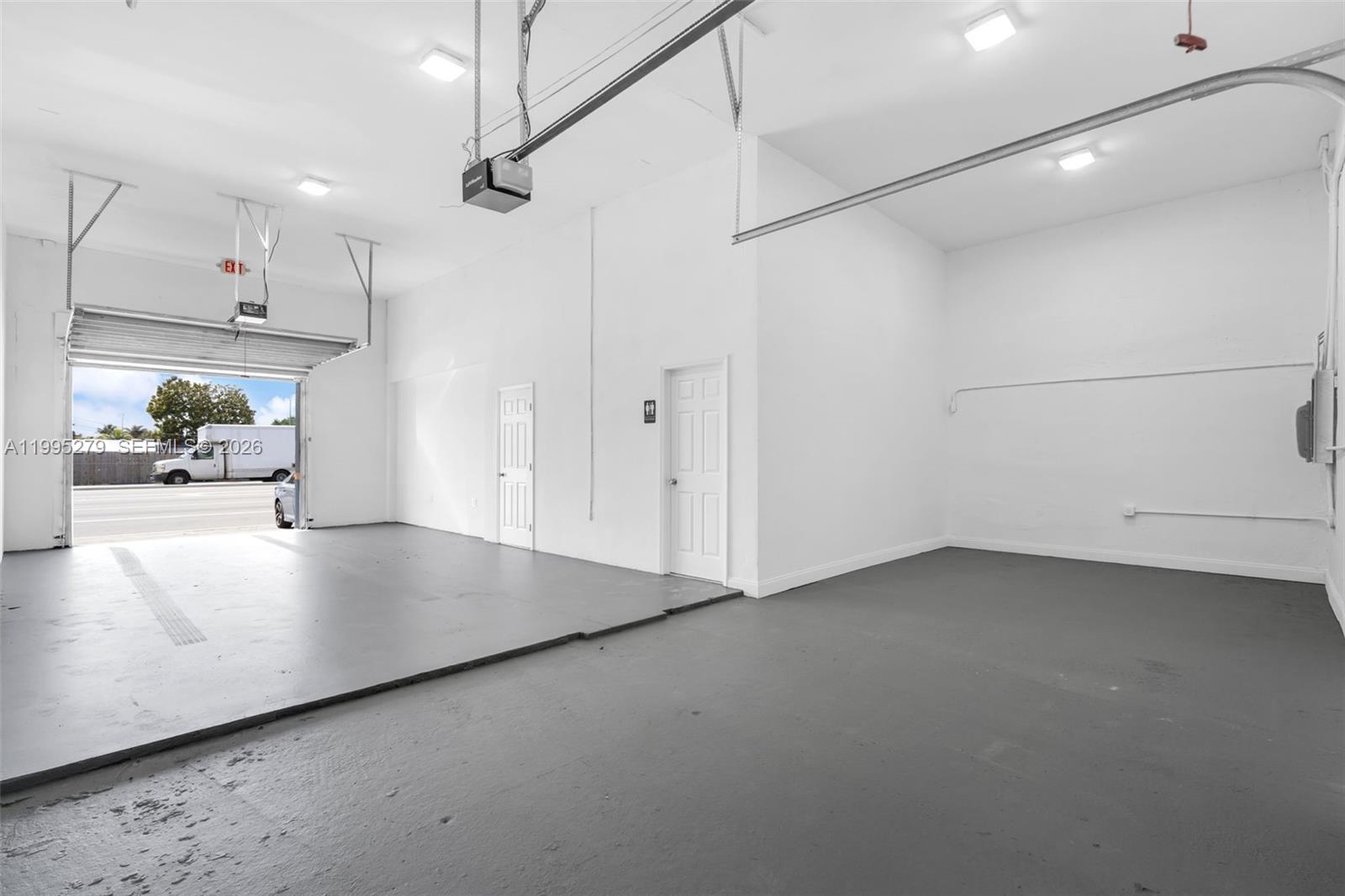 An empty garage features white walls, a gray painted floor, and two interior doors — 4255 E 8th Ave # 3, Hialeah FL 33013, HIALEAH, FL