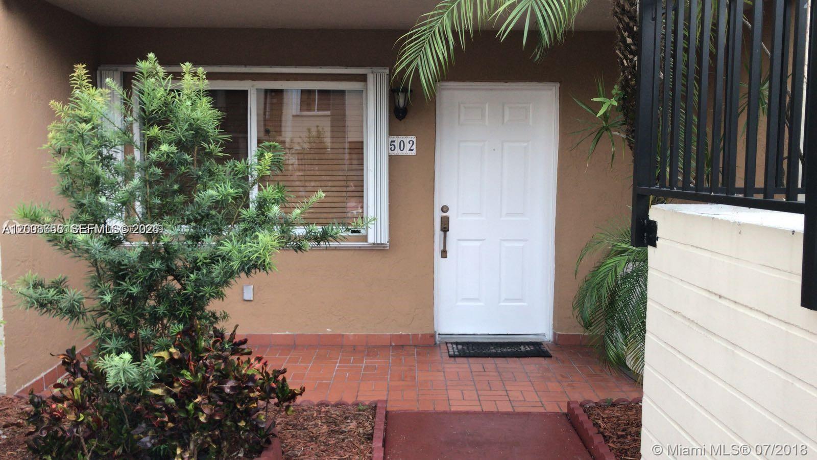 A white front door with the number 502 sits beside a window and a plant — 551 NW 82nd Ave # 502, Miami FL 33126, MIAMI, FL