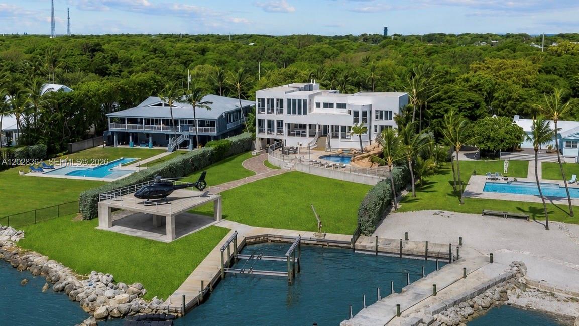 An aerial view shows a waterfront property featuring a helicopter pad, swimming pools, and docks — 89401 Old Highway, Plantation Key FL 33070, PLANTATION KEY, FL