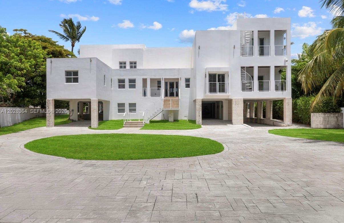 A white multi-story house with a circular driveway and elevated living spaces on pillars — 89401 Old Highway, Plantation Key FL 33070, PLANTATION KEY, FL