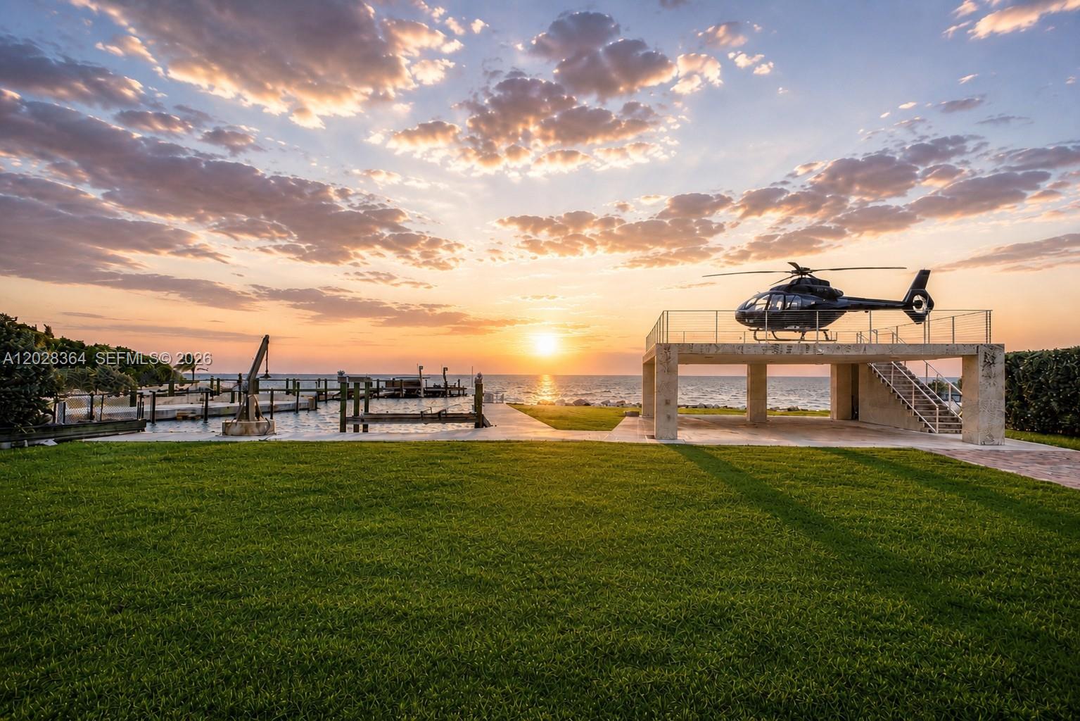 A helicopter sits on a raised concrete landing pad overlooking a dock and the ocean — 89401 Old Highway, Plantation Key FL 33070, PLANTATION KEY, FL