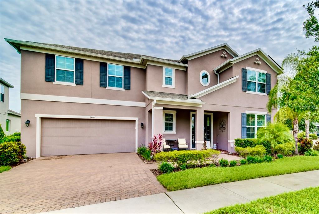 A two-story suburban house with a beige stucco exterior, a two-car garage, and blue shutters — 14301 WHITE MOSS WAY, WINTER GARDEN, FL