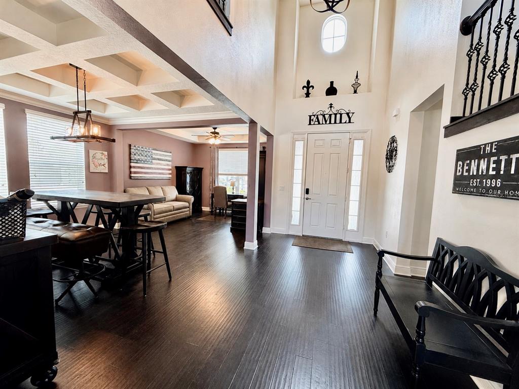 An entryway with dark wood floors leads to a dining area with a coffered ceiling — 14301 WHITE MOSS WAY, WINTER GARDEN, FL