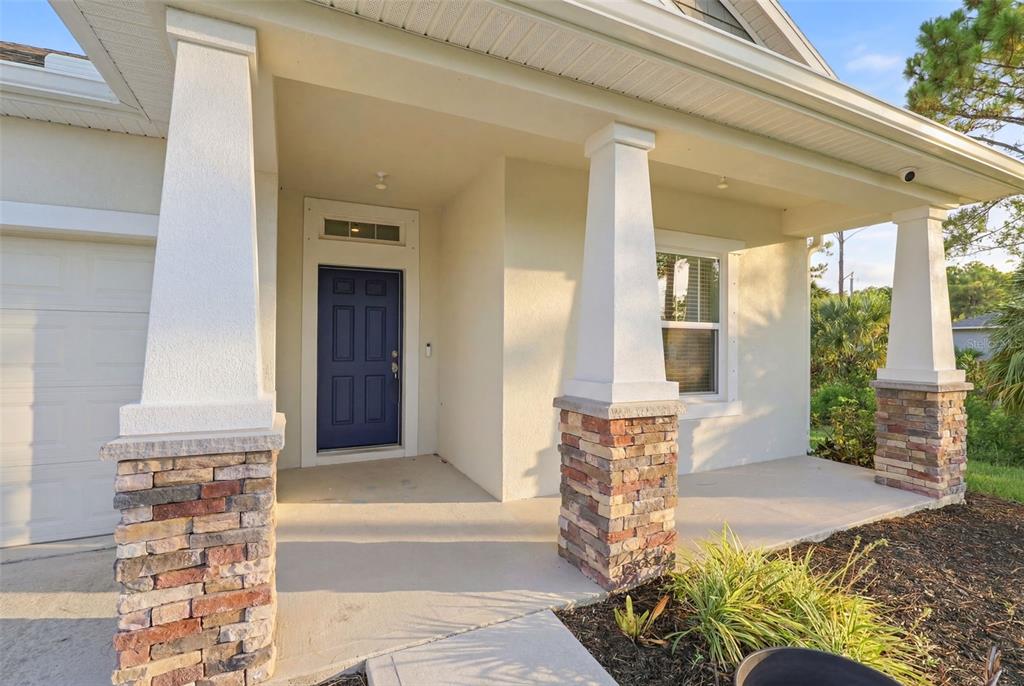 An entryway with a white front door and an adjacent room featuring wood-look flooring — 242 HERITAGE ST STREET SW, PALM BAY, FL